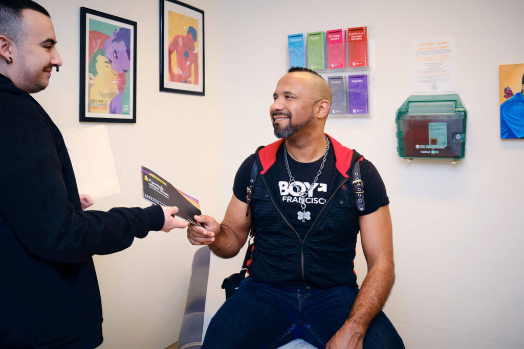 Clinic staff at Strut hold an Apretude vial and open injection kit next to an injectable PrEP brochure.